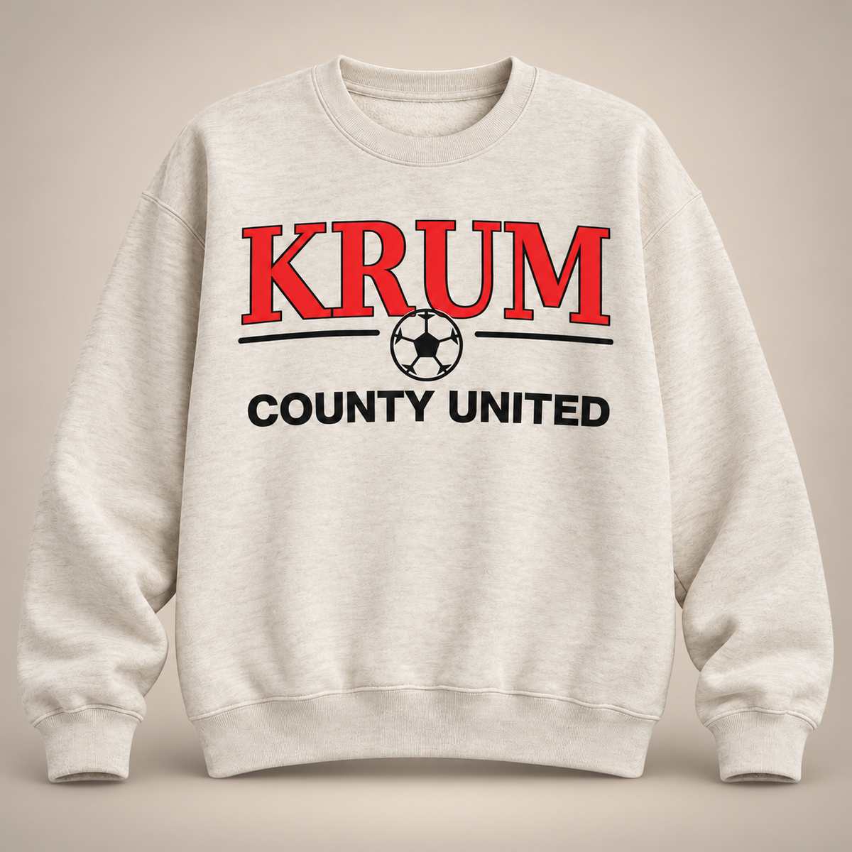 Oatmeal women's crewneck sweatshirt with red collegiate KRUM lettering and a black soccer graphic.