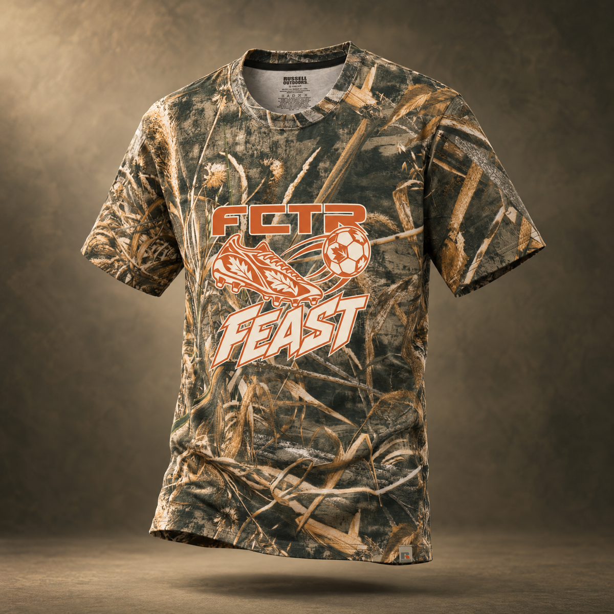 Adult Autumn Kick realtree camo t-shirt in Realtree Max 5 with an orange FCTR Feast soccer cleat and ball graphic, front view.