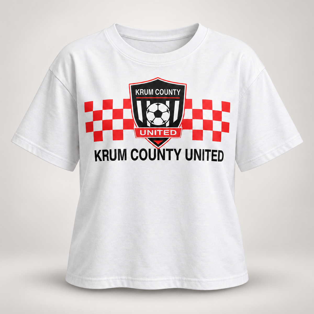 White boxy Krum County United tee with a red checker bar, club crest, and black club lettering.